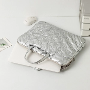 Detailed view of silver quilted bow texture on the water-resistant laptop sleeve