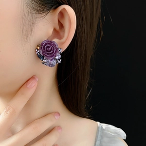 Macro detail of luxury vintage purple rose flower earrings with shimmering crystals