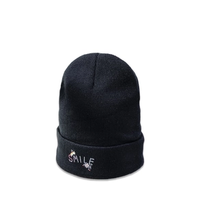 Close-up of smile and rainbow embroidery detail on the black knitted beanie hat
