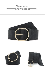 Détail d'une large ceinture noire mate avec une grande boucle ovale dorée et polie