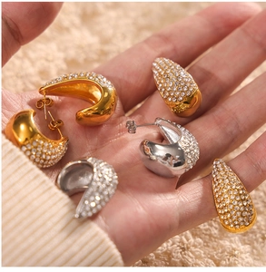 Gros plan d'un ensemble de bijoux en or et argent avec boucles d'oreilles et bagues en strass