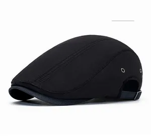 Detail of black flat cap showing micro-grid fabric texture and metallic side air vents