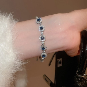 Detail of a silver bracelet featuring a square blue gemstone and micro-paved zircon stones