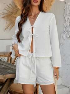 Detail von weißem Zweiteiler-Set aus Leinen mit langärmeliger Strickjacke und Shorts mit Band