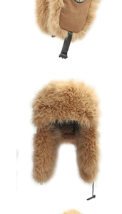 Detailed view of brown faux fur trapper hat with chin strap buckle and sport badge