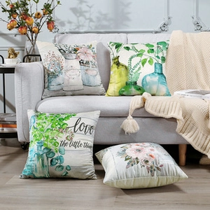 Detail of four sunflower linen pillow covers with hand-painted floral prints and text