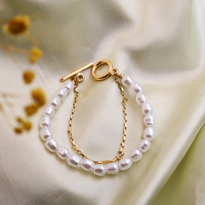 Detail of double-layer pearl bracelet with gold chain and classic T-bar toggle clasp