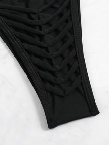 Detailed view of black bikini bottom featuring hollow woven straps and double stitching