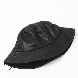 Detail of glossy metallic bucket hat fabric with reinforced stitching on the brim