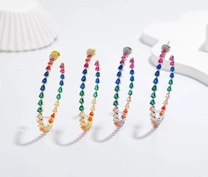 Detailed shot of gold and silver hoop earrings with pear-cut rainbow cubic zirconia