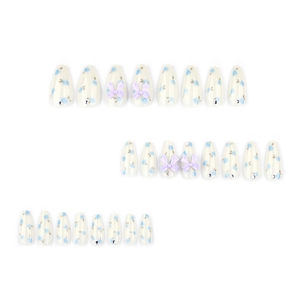 Blue floral press-on nails with purple 3D bows and rhinestones in long almond shape