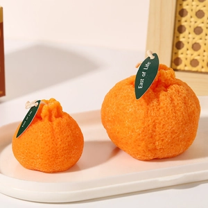 Set de dos velas aromáticas con forma de naranja realista, piel rugosa y etiquetas verdes
