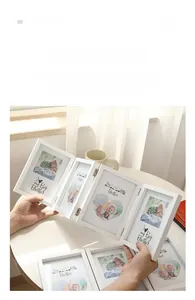 White four-panel folding photo frame in minimalist Nordic style on a desk