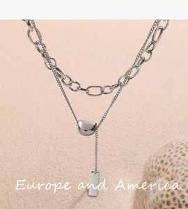 Detail of silver double layer stainless steel necklace with bean and bar pendants