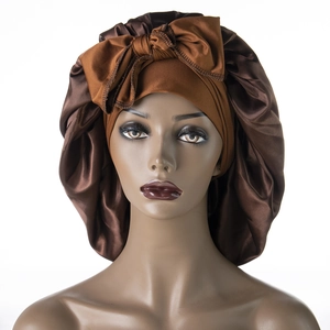Brown satin sleep bonnet with a large decorative bow for curly hair care