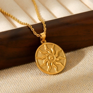 Close-up of golden stainless steel sun totem pendant on twisted rope chain necklace