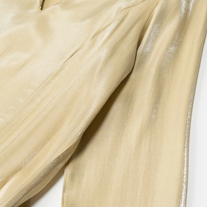 Nahaufnahme von champagnerfarbenem Satinstoff mit glatter Textur und elegantem Faltenwurf