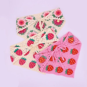 Detail view of handmade crochet bandanas featuring strawberry and floral patterns