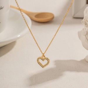 Elegant 18k gold plated heart necklace with zircon crystals on a warm beige background