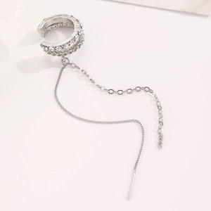 Macro detail of silver tassel ear cuff featuring sparkling rhinestones and long chain fringe