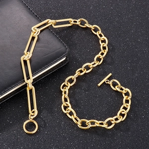 Detail of golden stainless steel mixed link chain bracelet with toggle clasp on dark surface