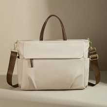 Off-white nylon handbag featuring dark brown leather handles and gold-tone hardware