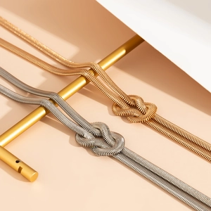 Flache Schlangenkette mit Knotendesign in Gold und Silber auf einem Displayständer