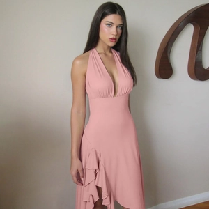 Detail of pink halter neck dress featuring deep V-neckline and ruffled asymmetric hemline