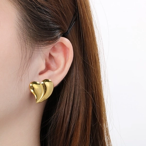 Irregular 18K gold heart stud earrings shown on model for a stylish minimalist look