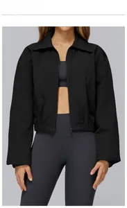 Detail of matte black windbreaker jacket featuring zip closure and elasticated hem