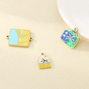 Detail of beach themed enamel charms with palm trees and waves for DIY jewelry making
