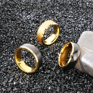 Macro detail of polished gold and black tungsten rings on volcanic stone background