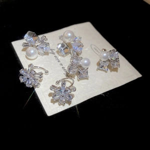 Detailed view of silver flower ear clips with pearls and sparkling cubic zirconia stones
