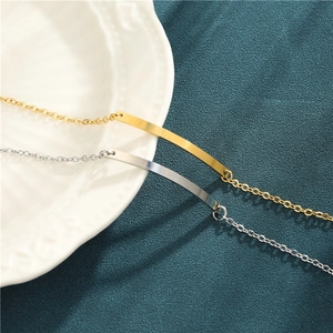Minimalist gold and silver stainless steel rectangular bar bracelets on a ceramic plate