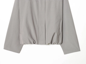Detailed view of grey pinstripe bomber jacket with elastic hem and textured fabric