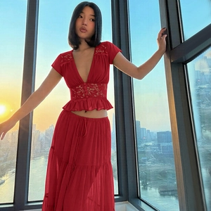 Détail du cardigan en mousseline rouge et jupe longue avec dentelle et col en V