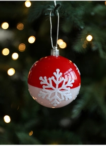 Gros plan d'une boule de Noël rouge et blanche avec un motif de flocon de neige détaillé