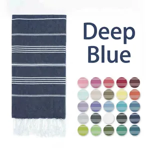 Navy blue Turkish beach towel with white stripes and tassels beside a 25-color swatch grid