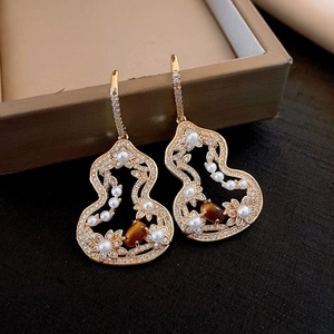 Détails des boucles d'oreilles gourde dorées avec perles et pierres œil de tigre