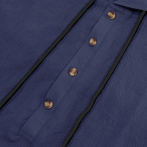 Close-up of navy blue linen shirt fabric texture and amber resin buttons detail
