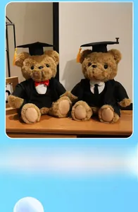Detail of graduation teddy bears in black gowns and caps on a rustic wooden desk
