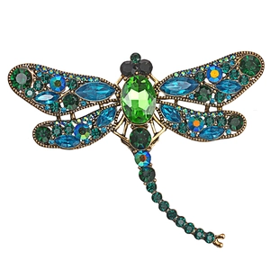 Vintage bronze dragonfly brooch with vibrant blue and green crystals on white background