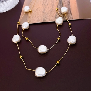 Detail of layered stainless steel necklace with baroque pearls and gold beads on leather