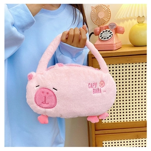 Detail of pink plush Capybara backpack held by a model in a cozy home setting