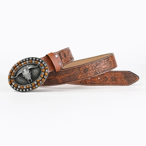 Macro detail of embossed floral leather belt and rustic bull head metal buckle with rhinestones