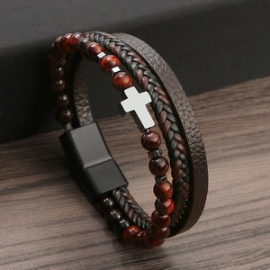 Detail of men's leather bracelet with red tiger eye beads and silver metal cross charm