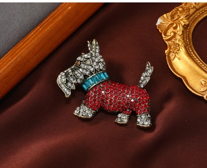 Detail of vintage Scottie dog brooch with red and white rhinestones on silk background