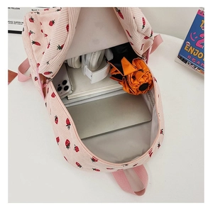 Detailed view of pink corduroy backpack interior storage for laptop and books
