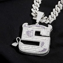 Macro shot of a purple devil-themed hip hop pendant encrusted with sparkling zircons