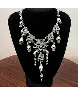 Detailed view of silver skull necklace with gothic bone tassel and metal pendant